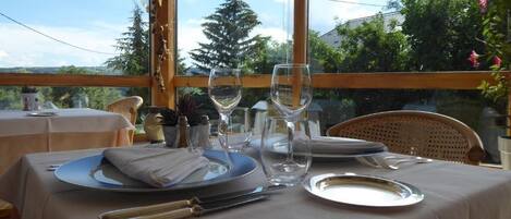 Mesa lista para comer con vista a árboles y un edificio al fondo.
