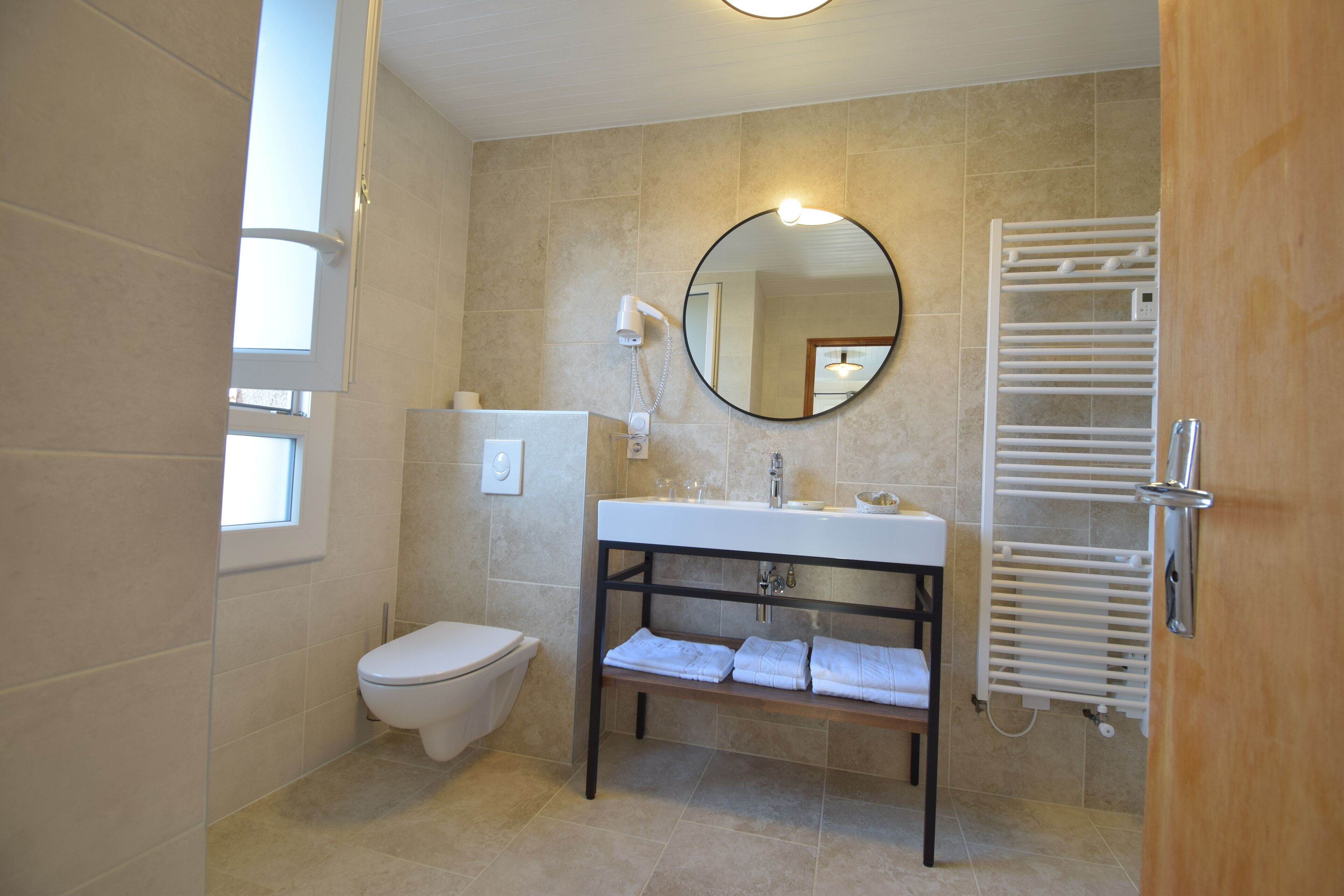 Un bagno moderno con toilette, lavandino e porta asciugamani.