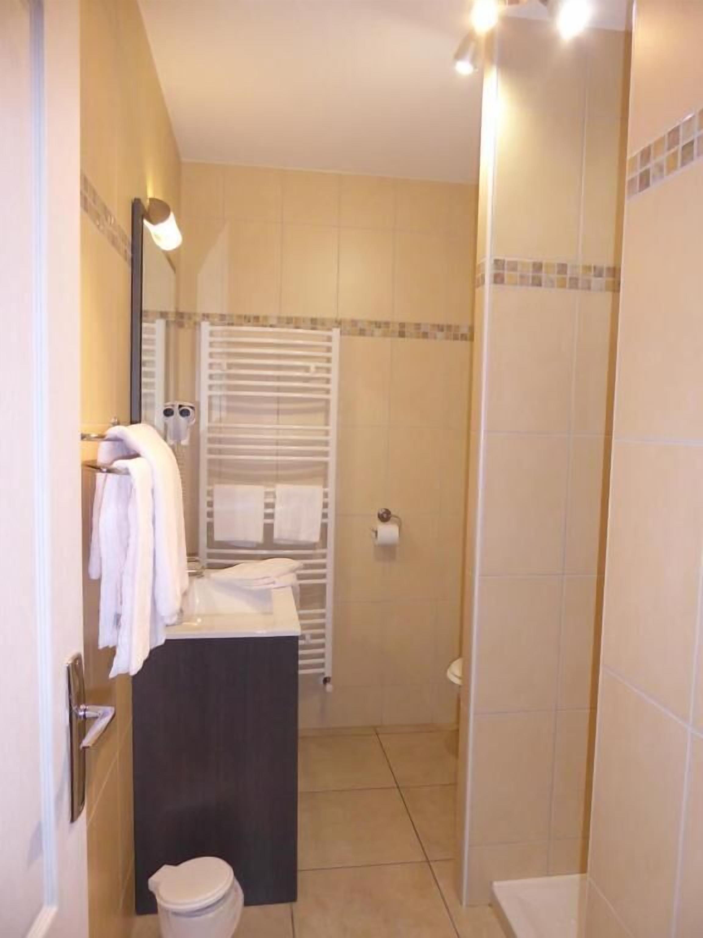 A bathroom with a toilet, sink, and shower area.