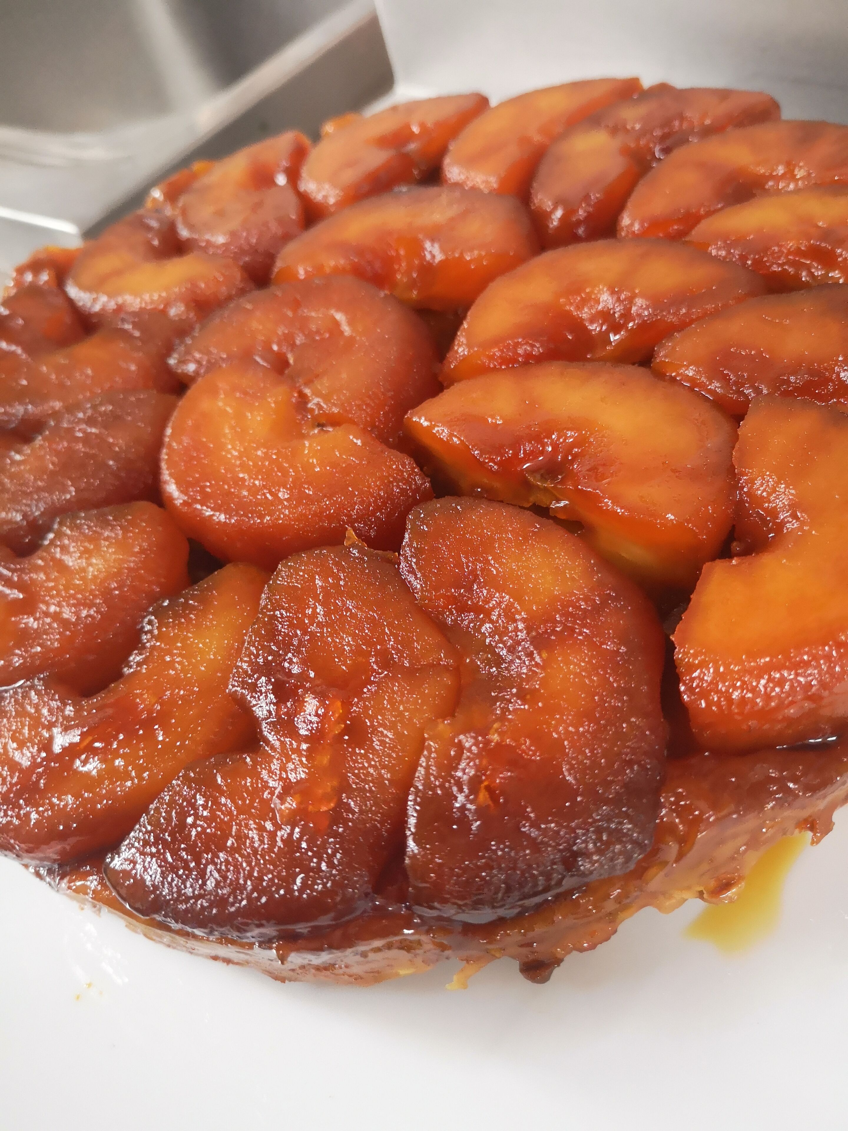 Primer plano de una tartaleta de fruta glaseada con superficie brillante y caramelizada.