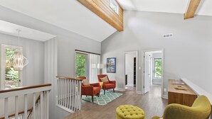 A spacious living area with a high ceiling, wooden flooring, and a view of the outdoors. - Carolina Sunrise by SoCharm | Amazing Sunrises | Hot tub (Denver)