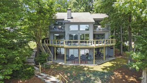 A modern two-story house with a balcony and outdoor seating area. - Carolina Sunrise by SoCharm | Amazing Sunrises | Hot tub (Denver)