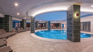 A modern indoor pool area with lounge chairs and a circular pool. - Aletris Deluxe Hotel & Spa (Manavgat)