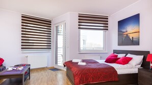 Une chambre moderne avec un lit, une table et une chaise, ainsi qu’une fenêtre avec des stores.