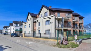 Un immeuble d’habitation à plusieurs étages, doté d’une entrée sécurisée et surplombant un ciel dégagé.