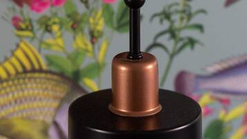 A black and copper hanging lamp with a black shade and a copper base.