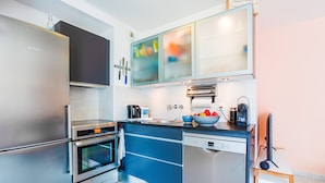 A modern kitchen with stainless steel appliances, a dishwasher, and a countertop with a bowl of fruit. - PALAIS LIBERTE V AP4267 By Riviera Holiday Homes (Niza)