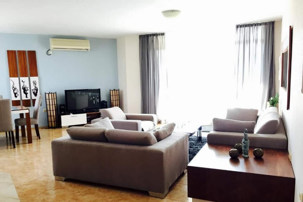 Una sala de estar moderna con un sofá, una mesa de centro y un televisor de pantalla plana.