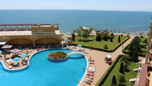 A resort with a large pool, sun loungers, and a view of the sea. - Aheloy Palace Apartments (Pomorie)