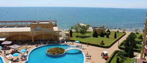 Una piscina al aire libre de temporada, sombrillas