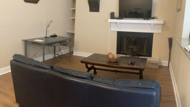 Un salon avec un canapé, une cheminée, un téléviseur et une petite table.