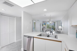 A modern kitchen with a central island, a dishwasher, and a sink.
