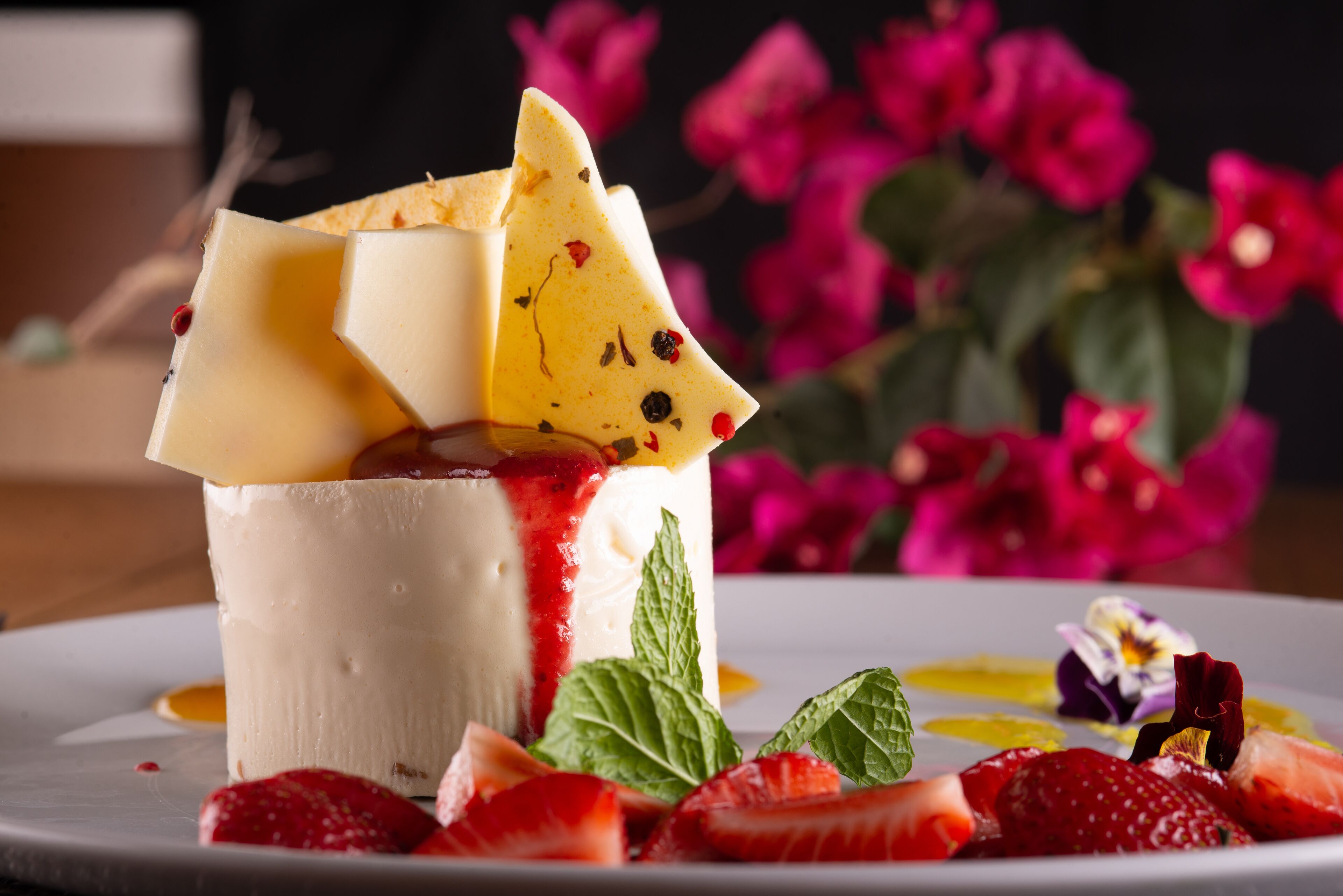 A dessert with fruit and mint on a plate.