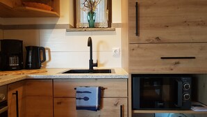 Une cuisine équipée d’un évier, d’une machine à café et d’un four à micro-ondes.