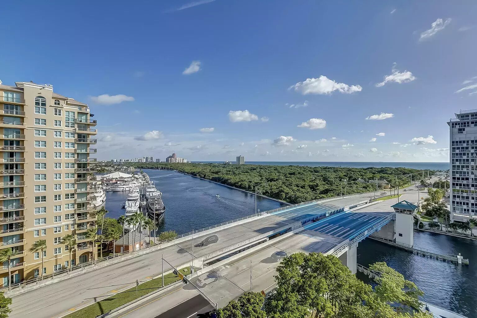 Een hoog hotel met balkons met uitzicht op een rivier en een brug.