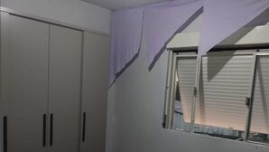 A bedroom with a bed, wardrobe, and window.