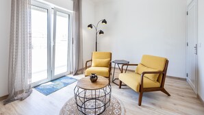 A modern living room with two yellow armchairs, a round coffee table, and a floor lamp.