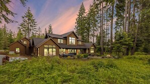 A large, modern log cabin with multiple large windows and a covered outdoor area. - Alpine Star | Stay on the Green @ Family Friendly Rates (Cle Elum)