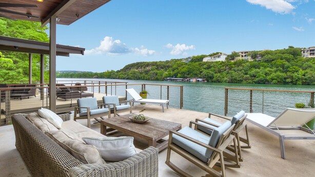A covered outdoor seating area with a view of a river and hills. - Above Lakeside I Lakefront | Pickleball I Pool/Spa l Firepit I Luxe Services (Austin)