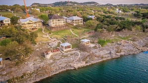 Vue aérienne d’un quartier résidentiel situé sur la côte, avec des maisons, un belvédère et une côte rocheuse.