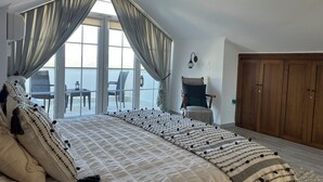 A bedroom with a large bed, a wooden wardrobe, and a view of the outside balcony. - Villa Ayshella , Luxury Ovacik Villa with stunning mountain views and sunsets (Ovacık)