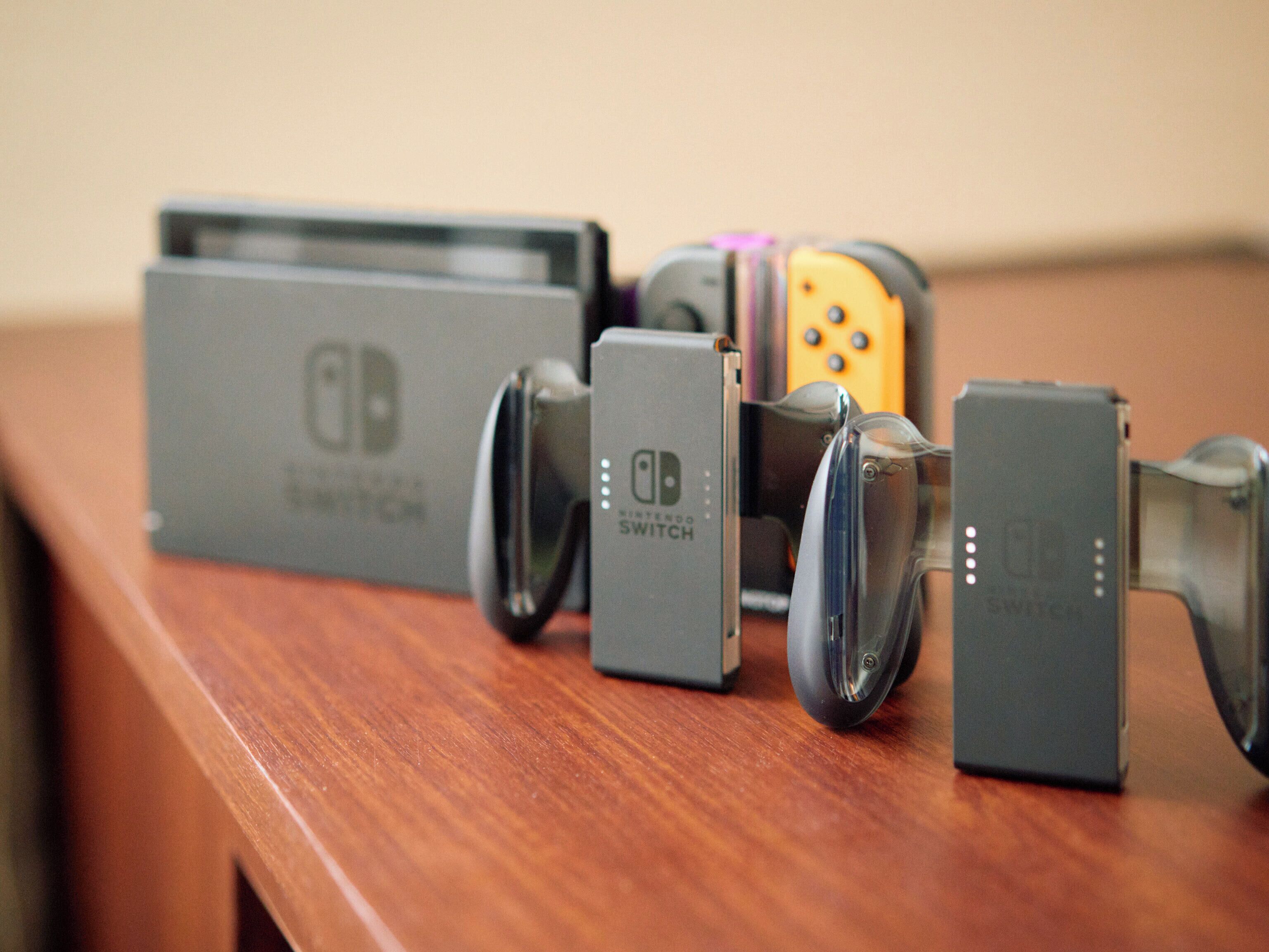 A Nintendo Switch console and accessories on a wooden surface.