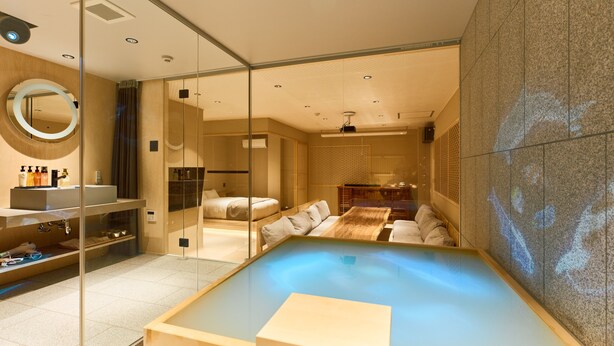 A modern spa room with a large bathtub, a glass-enclosed shower area, and a wooden bench. - KONJAKUSO Osaka Tempozan "IKESU" Projection Mapping SPA "TAKADORO" Wheel View (Osaka)