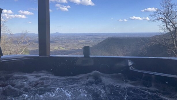 A hot tub with a view of a mountainous landscape.