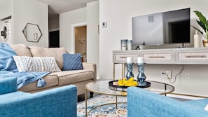 A modern living room with a sofa, coffee table, and TV.