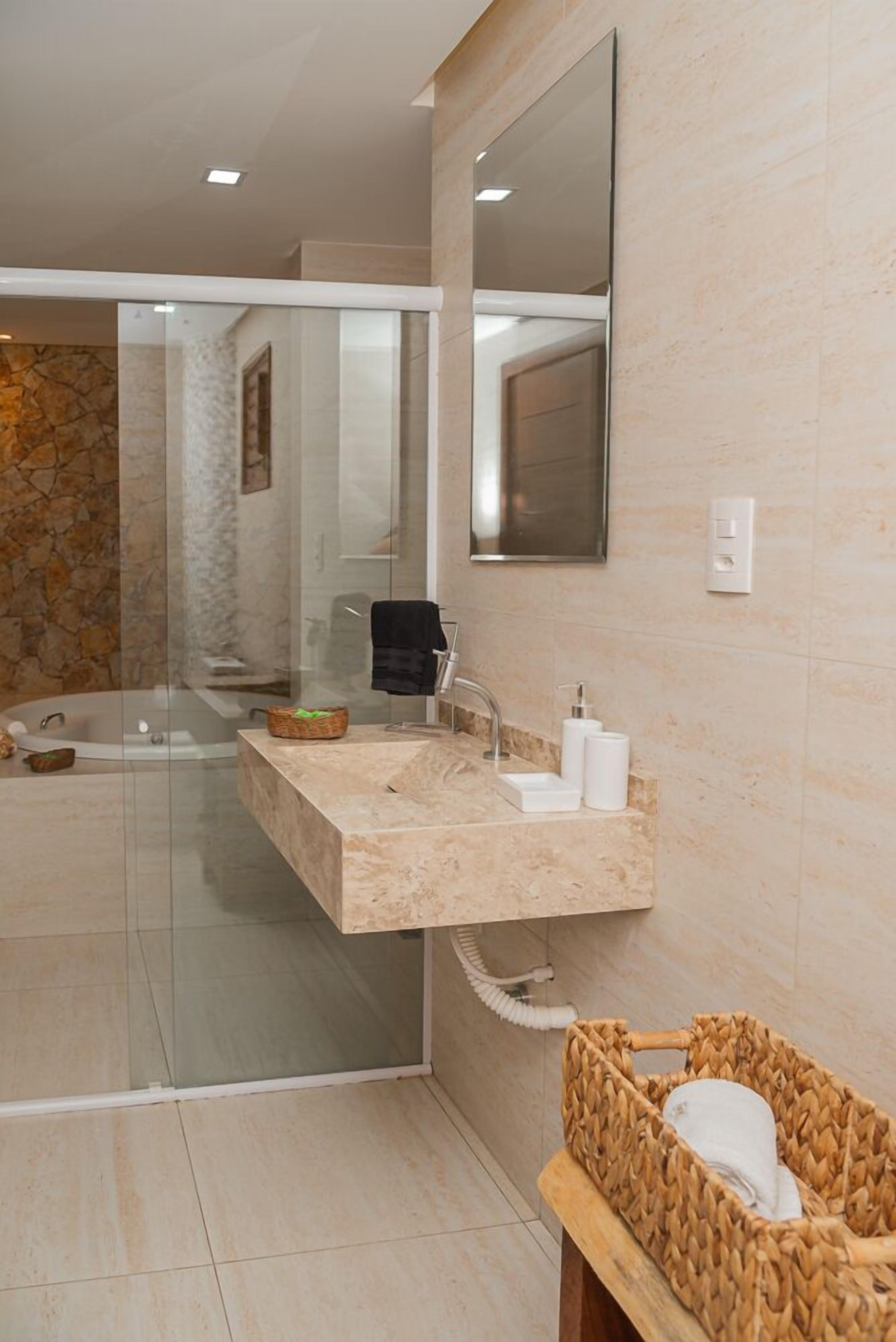 Une salle de bain moderne avec un lavabo sur pied, une baignoire et une douche à l’italienne.