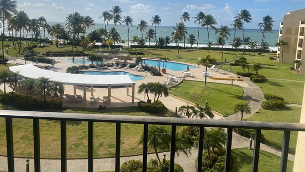 Ein Resort mit Pool, Palmen und Meerblick.