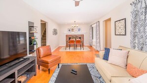 Ein Wohnzimmer mit Fernseher, einer Ledersofa, einem Couchtisch und einem Kamin.
