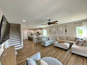 Relax in this stylish living area with a sofa set, dining table, and staircase leading to an upper level.