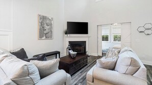 Una sala de estar con chimenea, un televisor de pantalla plana y dos sofás.