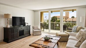 Una sala de estar con televisor, sofá y mesa de centro.