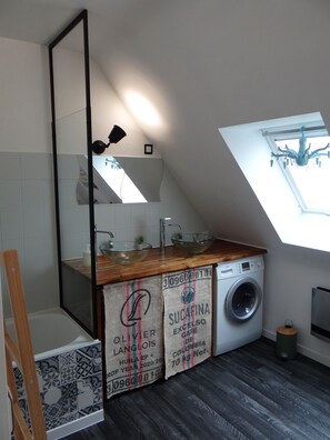 Een bad/douchecombinatie, een haardroger, handdoeken, toiletpapier