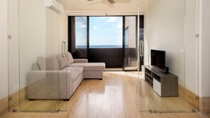 A modern living room with a sectional sofa, a flat-screen TV, and a ceiling fan. - Heart of Cozumel w/ Rooftop Pool DC 501 (San Miguel de Cozumel)