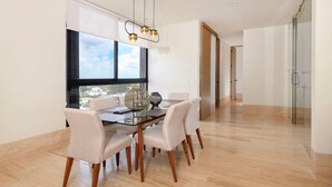 A modern dining area with a glass table, six chairs, and a decorative vase. - Heart of Cozumel w/ Rooftop Pool DC 501 (San Miguel de Cozumel)