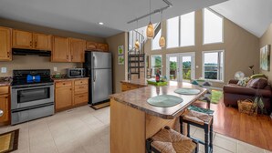 Una cocina moderna con armarios de madera, electrodomésticos de acero inoxidable y una isla grande con taburetes.