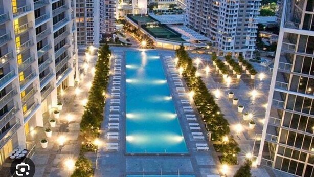 A high-rise hotel with a central swimming pool surrounded by lounge areas and potted plants. - 0142 Skyline Serenity 1B/1B (Miami)