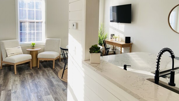 A modern living room with a sofa, a small table, and a TV.