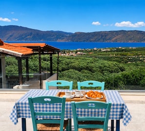 A table with a checkered tablecloth, two chairs, and a tray with food and drinks.