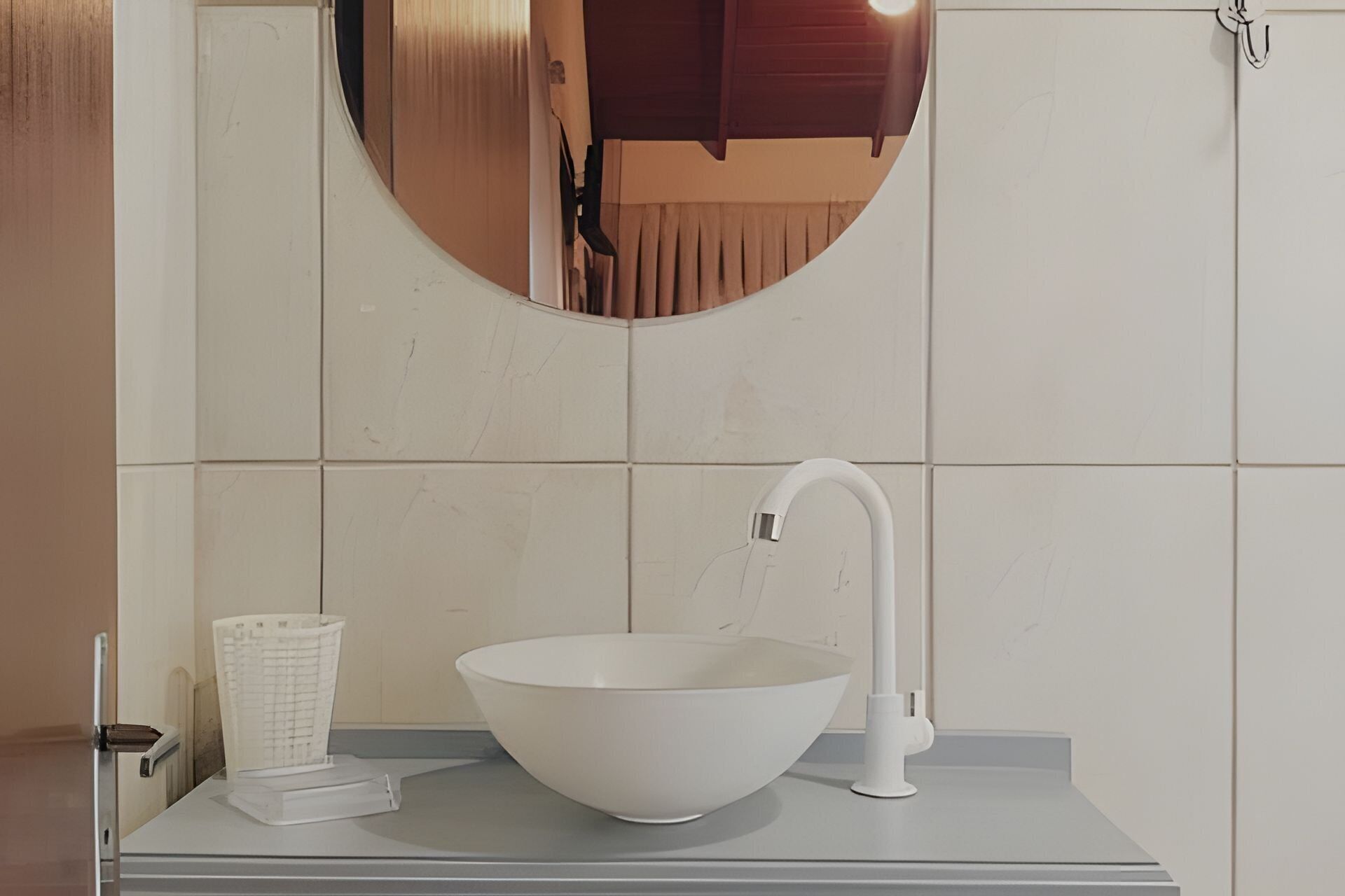 A bathroom with a white sink, a mirror, and a towel rack.