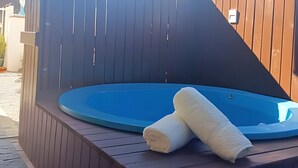 A hot tub with two towels on a wooden deck.