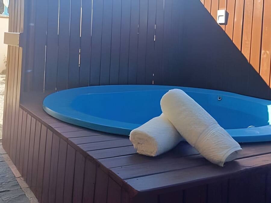 Un jacuzzi con dos toallas sobre una terraza de madera.