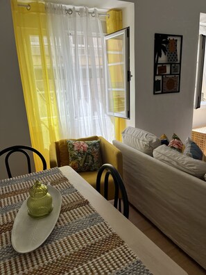 Relax in this inviting living space with a dining area, sofa, and decorative touches.