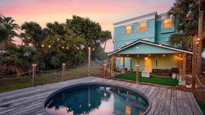 A house with a pool, a porch with string lights, and a view of the sky. - 5 bed 4 bath pool table, fire pit, walk to beach (Daytona Beach)