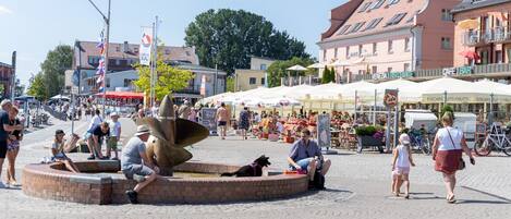 A public square with a central fountain, surrounded by cafes and restaurants.