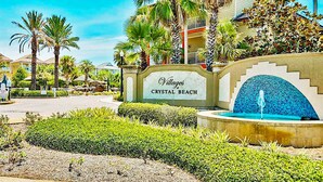 A sign for Crystal Beach Villas with a fountain and palm trees. - Excellent Management Steps From Beach Pool (Destin)