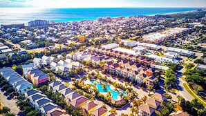 A resort with multiple buildings, a swimming pool, and a beach in the background. - Excellent Management Steps From Beach Pool (Destin)